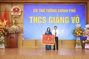 Thừa ủy quyền, Chủ tịch UBND quận Ba Đình Tạ Nam Chiến trao Cờ thi đua Chính phủ cho đại diện Trường THCS Giảng Võ.