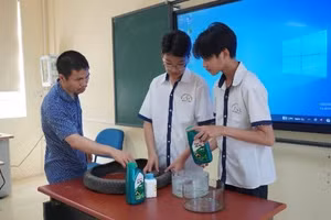 Thầy giáo Dương Quốc Trọng (bên trái) hướng dẫn học trò thực hiện dự án khoa học kỹ thuật. 