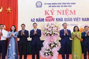 Chủ tịch UBND tỉnh Bắc Ninh Vương Quốc Tuấn (thứ 4 từ trái qua) cùng đại biểu tặng hoa chúc mừng ngành GD&ĐT.