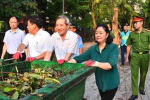 Bí thư Thành ủy Hà Nội Bùi Thị Minh Hoài tham gia vệ sinh môi trường cùng người dân tại Vườn hoa Vạn Xuân. Ảnh: VT.