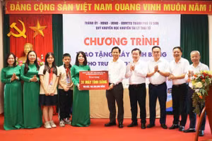 Bí thư Thành ủy Từ Sơn Lưu Đình Thực (thứ 5 từ phải qua) cùng đại biểu trao máy tính bảng cho cô trò Trường THCS Từ Sơn.