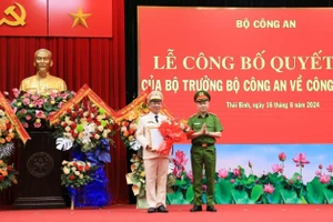 Thiếu tướng Nguyễn Ngọc Lâm, Thứ trưởng Bộ Công an, trao quyết định và tặng hoa chúc mừng Đại tá Trần Xuân Ánh.