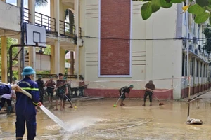 Cán bộ, chiến sĩ công an phối hợp cùng các thầy cô giáo dọn vệ sinh.