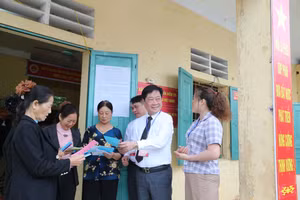 Ông Nguyễn Bá Khuyến, Bí thư Đảng ủy xã Yên Sơn (áo trắng) chia sẻ với cử tri tại khu vực bỏ phiếu số 10. 