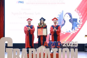 PGS.TS Nguyễn Bá Chiến (bên phải) trao bằng tốt nghiệp và chúc mừng tân cử nhân. 