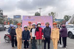 Hình ảnh lực lượng CSGT tặng mũ bảo hiểm hỗ trợ người dân trên đường về quê nghỉ Tết. 