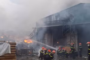 Cảnh sát dập tắt đám cháy tại xưởng tái chế phế liệu.