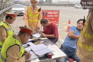 Công an làm việc với lái xe container (áo xanh).