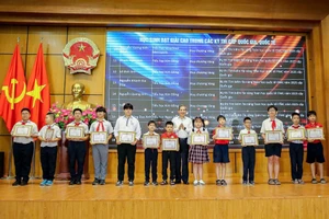 Bí thư Quận ủy Ba Đình Hoàng Minh Dũng Tiến trao khen thưởng cho các em học sinh.