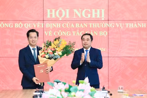 Bí thư Thành ủy Hà Nội Trần Đức Thắng trao quyết định và tặng hoa chúc mừng tân Trưởng Ban Tổ chức Thành ủy Hà Nội Vũ Đăng Định. Ảnh: QT