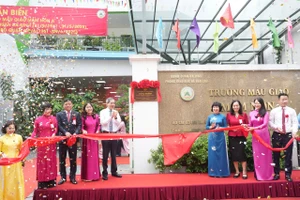 Các đại biểu thực hiện nghi thức gắn biển công trình chào mừng kỷ niệm 64 năm Ngày thành lập quận Ba Đình.
