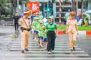 Cán bộ CSGT hướng dẫn các em cách sang đường theo đúng tín hiệu đèn và vạch kẻ đường.