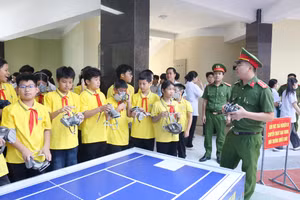 Cảnh sát hướng dẫn học sinh đeo mặt nạ phòng khói, khí độc khi gặp hỏa hoạn.