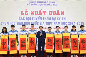 Phó Chủ tịch UBND tỉnh Bắc Ninh Lê Xuân Lợi trao tặng tranh chữ cho các em học sinh.