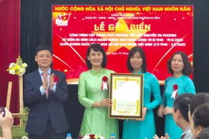 Phó Chủ tịch HĐND TP Hà Nội Phạm Quí Tiên trao bằng công nhận cho Ban Giám hiệu Trường Tiểu học Nguyễn Tri Phương. Ảnh: TT