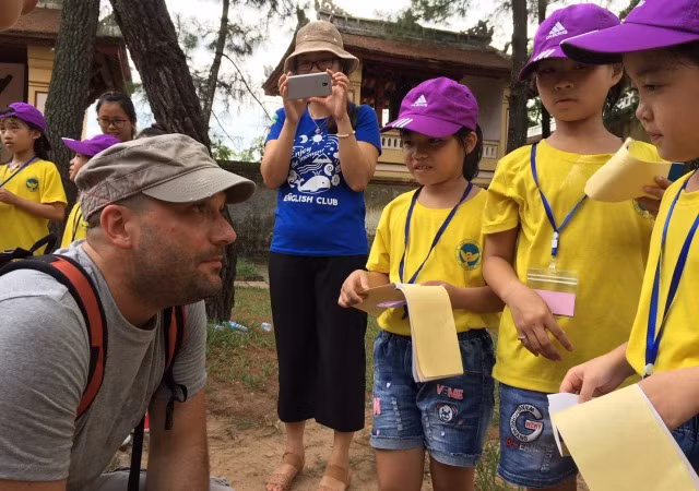 Du khách Italia đang giao lưu tiếng Anh cùng học sinh tại chùa Thiên Mụ