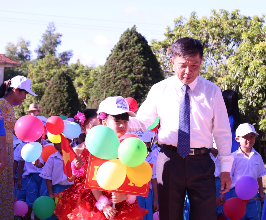 Chủ tịch UBND tỉnh Quảng Bình cùng đại biểu và giáo viên nhà trường đón các cháu học sinh lớp 1 bước vào năm học mới.