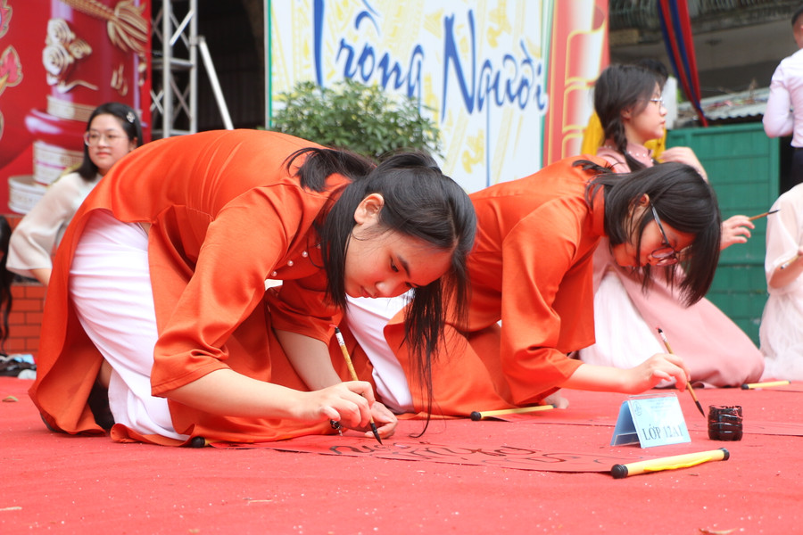 Các em tham gia thi Viết chữ thư pháp.