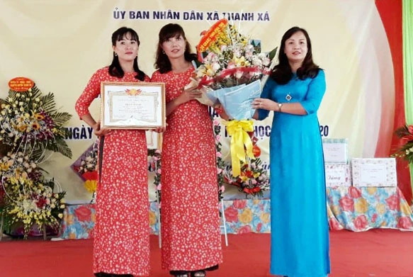 Phó Giám đốc Sở GD&ĐT - Nguyễn Thị Thu Huyền trao Giấy khen của Giám đốc Sở GD&ĐT và tặng hoa cho nhà trường.