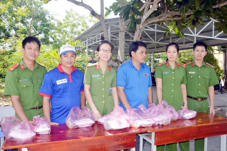 Chiến sĩ Công an và thanh niên tình nguyện cùng phát bữa cơm trưa cho sĩ tử