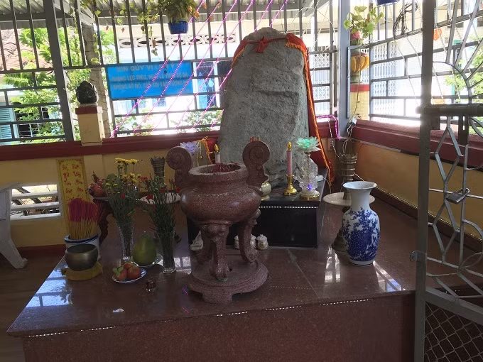 Tảng đá được thờ một cách trang nghiêm. Câu đối được treo góc khuất bên trái.