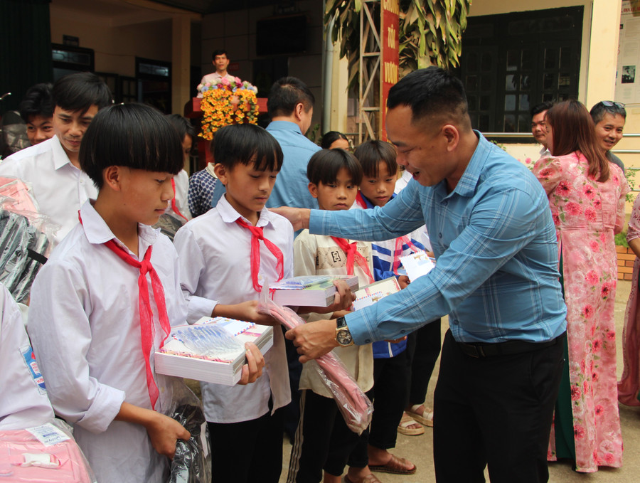 Nhà báo Nguyễn Minh Thịnh, Trưởng Văn phòng đại diện Báo Giáo dục và Thời đại khu vực Tây Bắc trao quà cho học sinh.