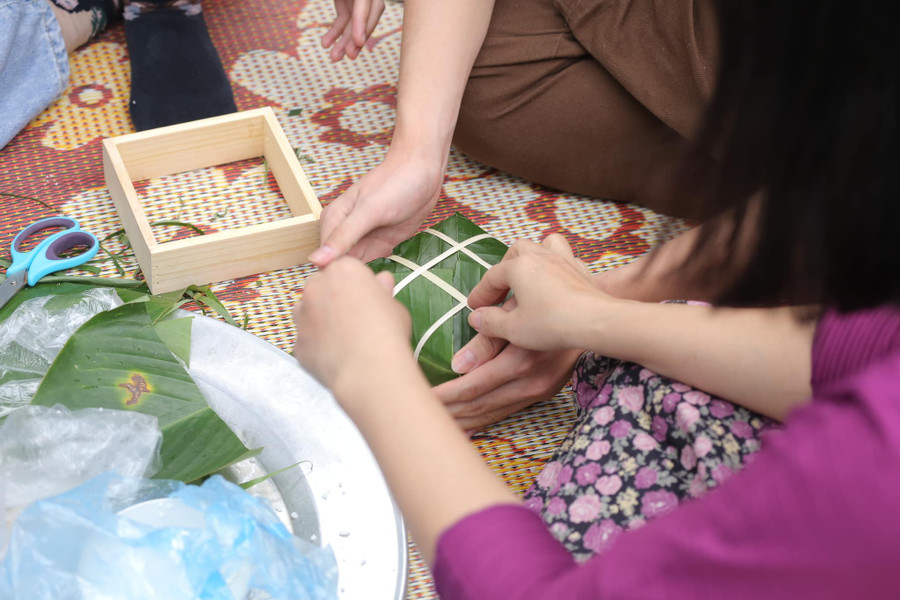 Học sinh cùng gói bánh chưng với phụ huynh tại trường. Học sinh cùng gói bánh chưng với phụ huynh tại trường.