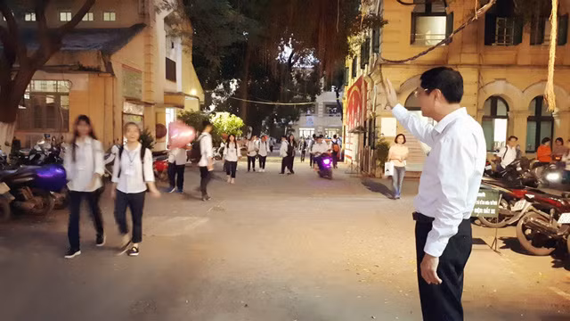 Bất kể nắng mưa sớm tối, thầy hiệu trưởng đều đứng chào đón học sinh ở cổng trường.