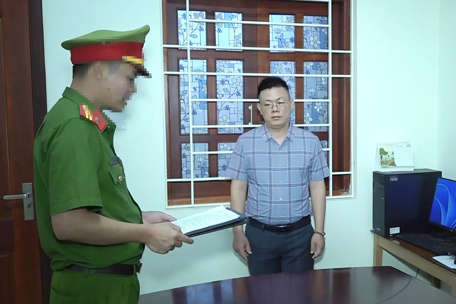 Công an đọc lệnh khởi tố, bắt bị can đối với Nguyễn Văn Khoa. Ảnh: CANA