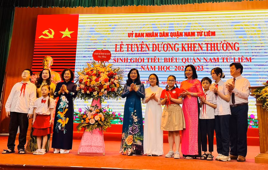 Đại diện cô trò ngành Giáo dục Nam Từ Liêm tiếp nhận lẵng hoa chúc mừng từ đại diện Sở GD&amp;ĐT Hà Nội.