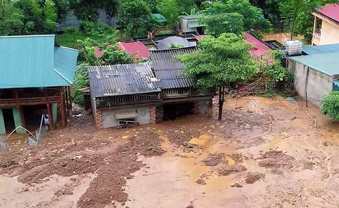 Nhiều nhà dân ở bản Co Me, xã Trung Sơn ngập trong bùn đất.