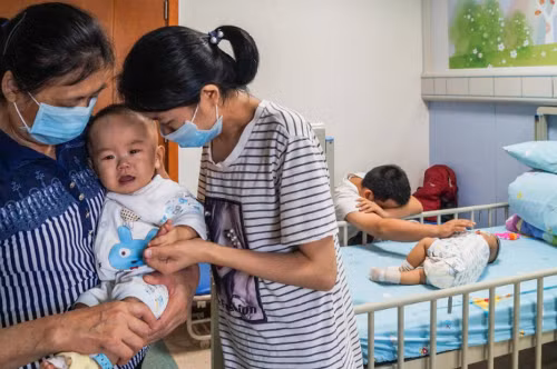 Bố mẹ hai bé quỵ ngã vì đau đớn. Ảnh: AsiaOne.