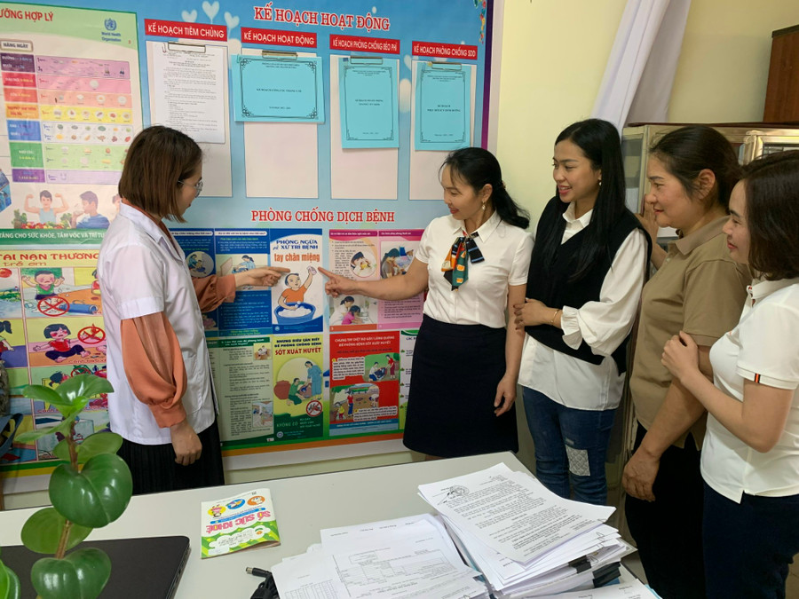 Cán bộ y tế trường học tuyên truyền, hướng dẫn giáo viên về dinh dưỡng, cách phòng ngừa bệnh cho trẻ.