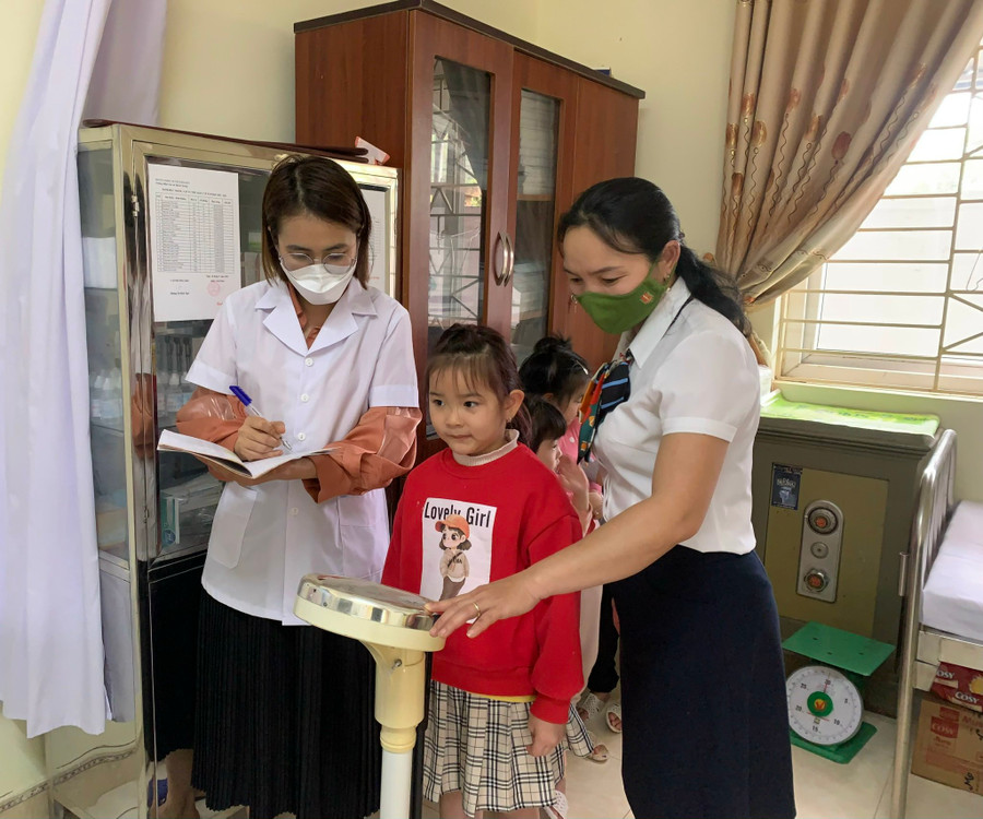 Cán bộ y tế trường Mầm non Thanh Xương theo dõi sức khoẻ cho trẻ.