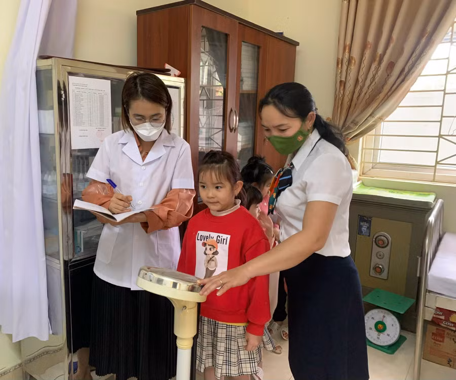 Cán bộ y tế trường Mầm non Thanh Xương theo dõi sức khoẻ cho trẻ.