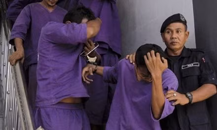 Cảnh sát dẫn giải các nghi phạm hiếp dâm tới một phiên tòa ở Malaysia. Ảnh: Independent.