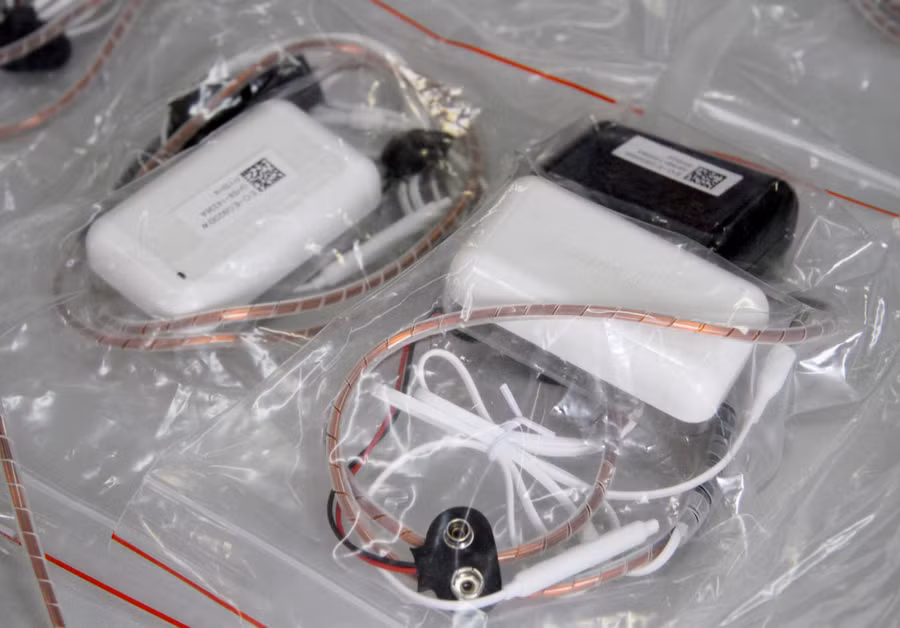 Tai nghe siêu nhỏ dạng vòng cổ gồm cuộn dây bằng đồng đeo trên cổ có chức năng phát sóng. Thiết bị này kết nối với bảng mạch điện tử thu - khuếch đại âm thanh và mic đàm thoại, hạt nam châm kích thước 2,5 mm có thể nhận sóng âm, làm rung màng nhĩ.