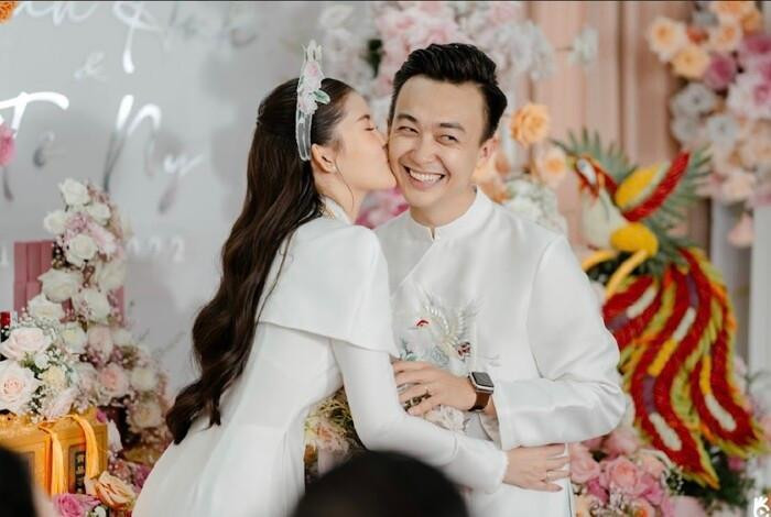 Chú rể Phan Tô Ny và cô dâu Lê Âu Ngân Anh chọn áo dài trắng cách tân trong ngày trọng đại của mình.