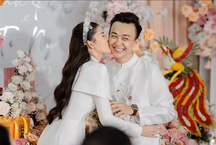 Chú rể Phan Tô Ny và cô dâu Lê Âu Ngân Anh chọn áo dài trắng cách tân trong ngày trọng đại của mình.