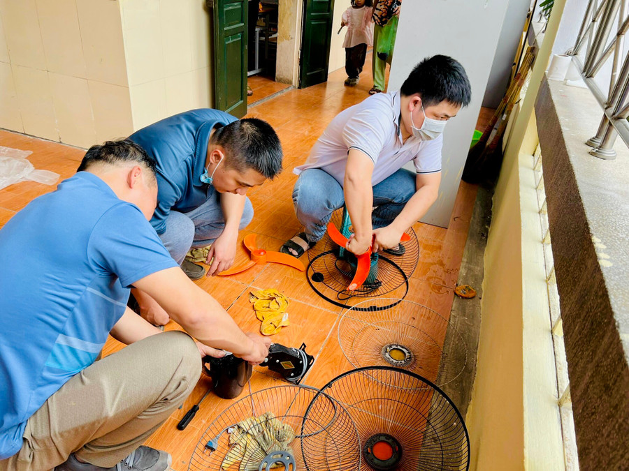 Phụ huynh cùng vệ sinh, sửa lại hệ thống quạt treo tường ở các lớp.