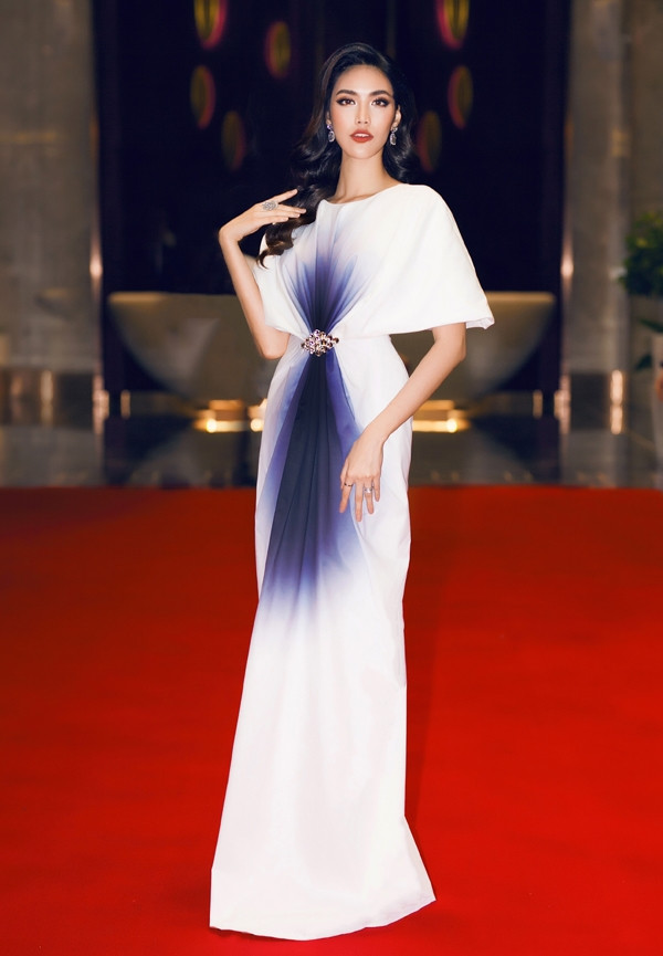 Bộ cánh của NTK Thanh Huy được tạo nên từ những đường gấp đối xứng hai bên thân váy. Điểm nhấn nằm ở phần chít eo nhẹ nhàng đi cùnghiệu ứng ombre tím tạo độ thon gọn cho vòng hai.