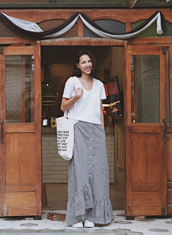 Áo thun trắng được sao Việt lựa chọn bởi dễ sử dụng và thoải mái phối đồ cùng nhiều kiểu dáng quần jean, chân váy midi, maxi, váy ngắn khác nhau. Minh Triệu với hình ảnh phóng khoáng và tự do cùng cách phối áo hợp mốt đi cùng chân váy maxi, túi vải đeo vai.