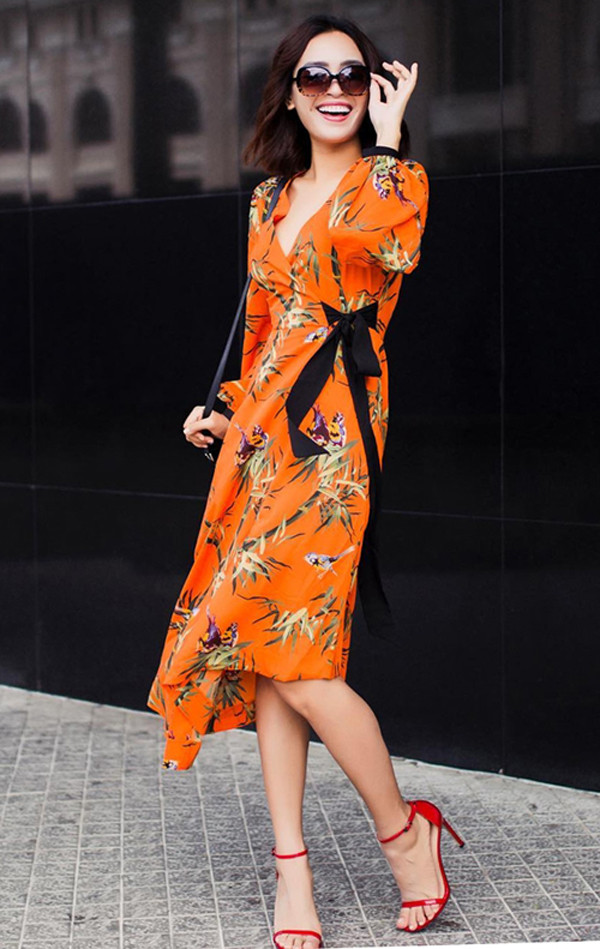 Ái Phương nổi bật trên phố với thiết kế váy vạt quấn in hoa văn hoa lá rực rỡ sắc hè nhiệt đới.