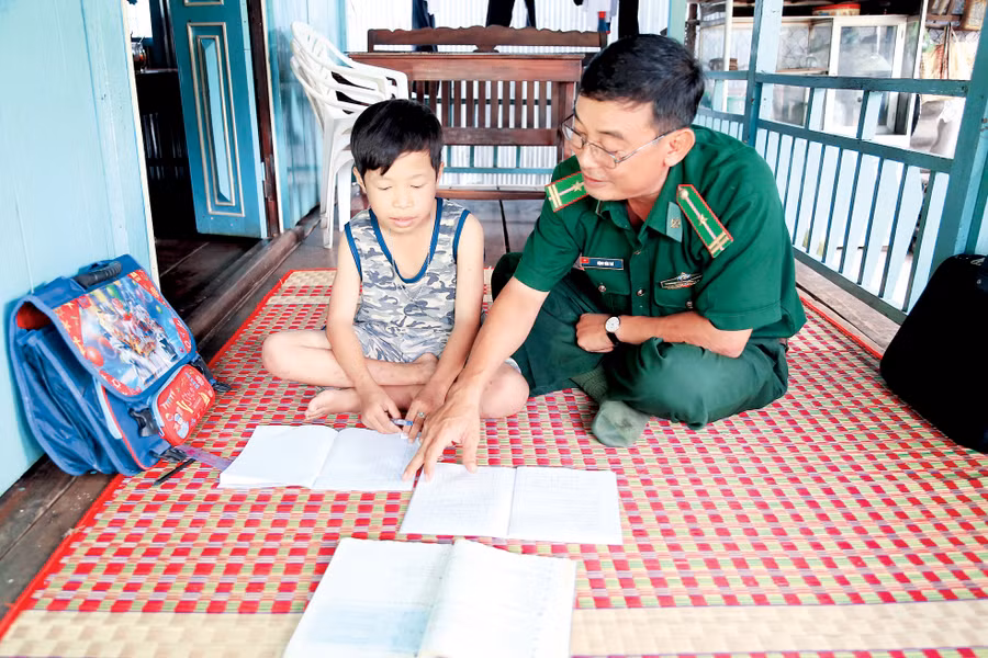 Cán bộ Đồn Biên phòng Bình Thạnh hướng dẫn các em làm bài tập sau giờ lên lớp