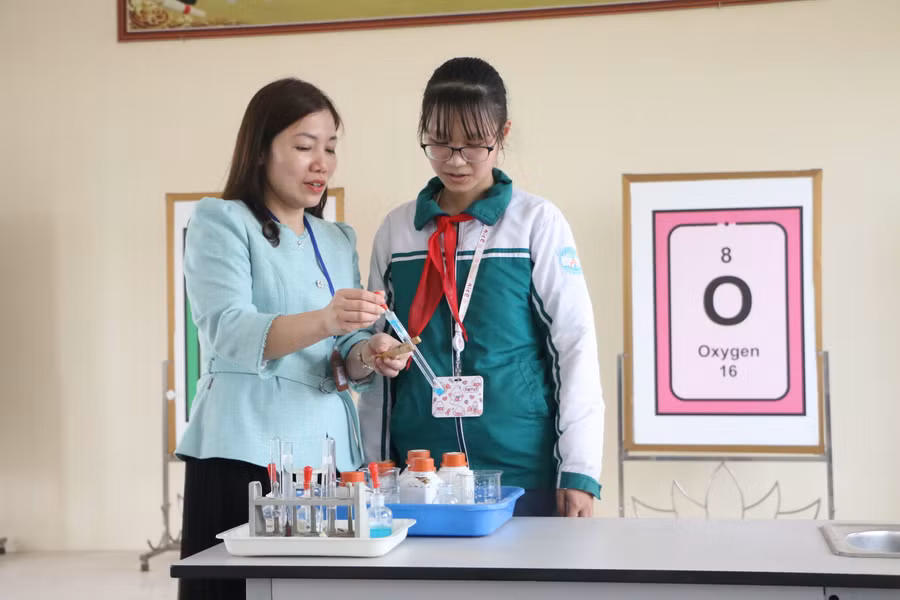 Cô Khuất Thị Hòa đang hướng dẫn làm một thí nghiệm hóa học cho em Khuất Đỗ Gia Như tại trường.