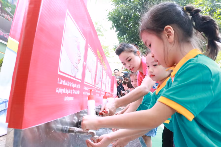 Cô trò Trường Mầm non Dịch Vọng Hậu (Cầu Giấy, Hà Nội) cùng nhau rửa tay bằng xà phòng dưới vòi nước chảy. Ảnh: Đình Tuệ.