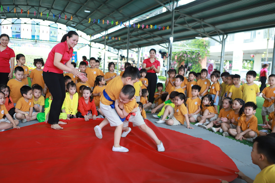 Trẻ tham gia đấu Vật để rèn luyện sức khỏe dưới sự cổ vũ của cô và các bạn.