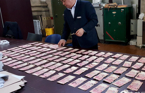 Số tiền của ông Wang được rửa sạch dưới vòi nước trước khi kiểm định. Ảnh: QQ.