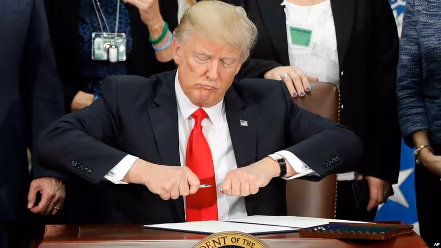 Tổng thống Donald Trump mở nắp bút trước khi ký sắc lệnh về di trú tại Bộ An ninh nội địa ngày 25/1/2017