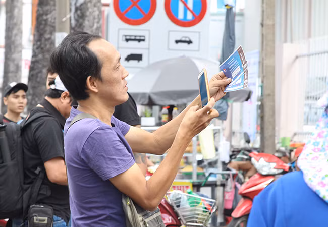 Một cổ động viên vui mừng và nhanh tay chụp lại 2 vé mình vừa mua được.